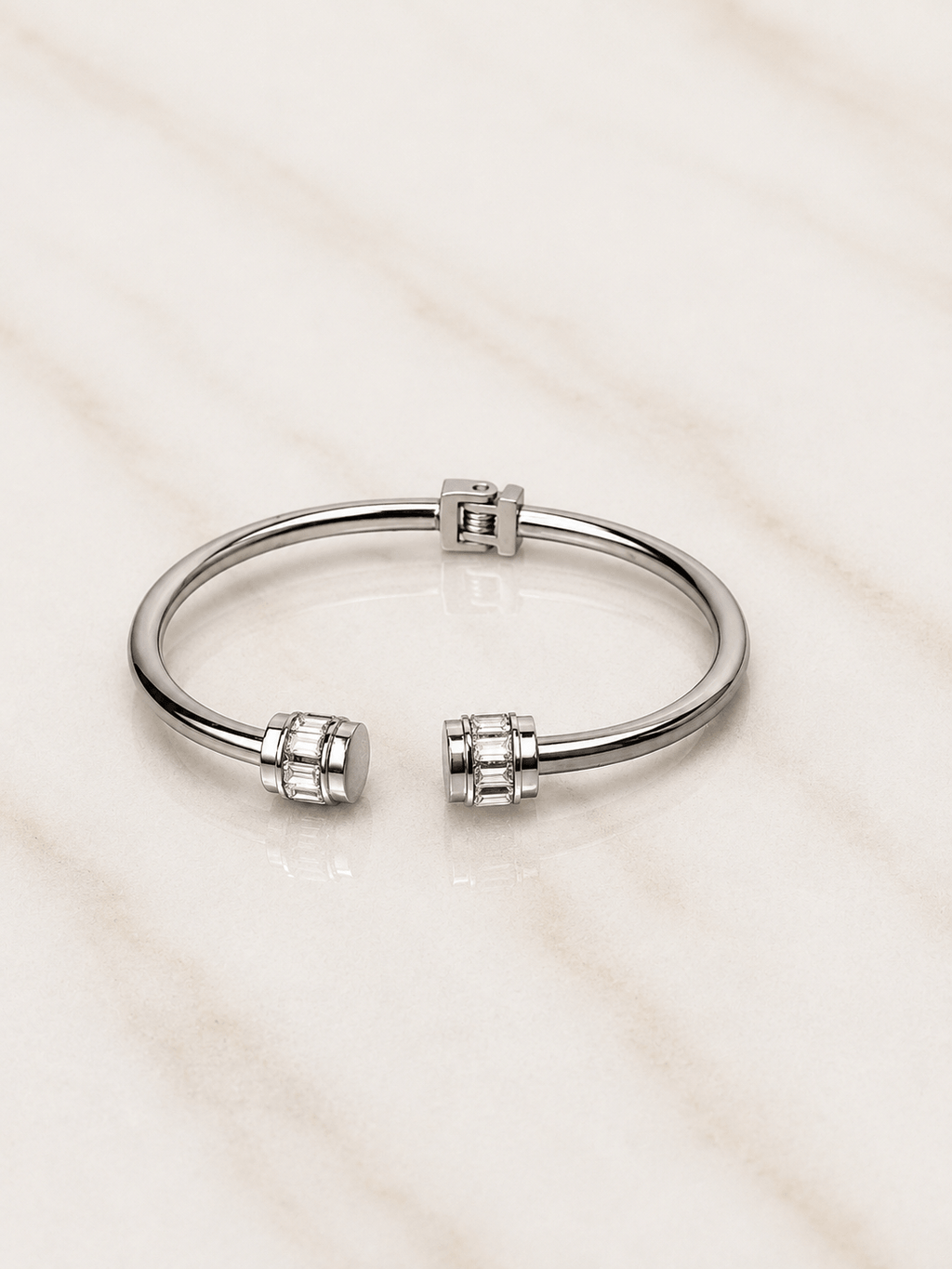 The Royal Radiance Cuff featuring a sleek design with baguette-cut crystal barrel accents on a marble surface.