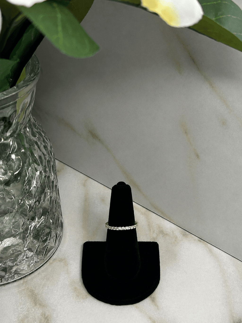 The Eternity Band Ring displayed alongside a decorative vase, showcasing its sparkling cubic zirconia stones.