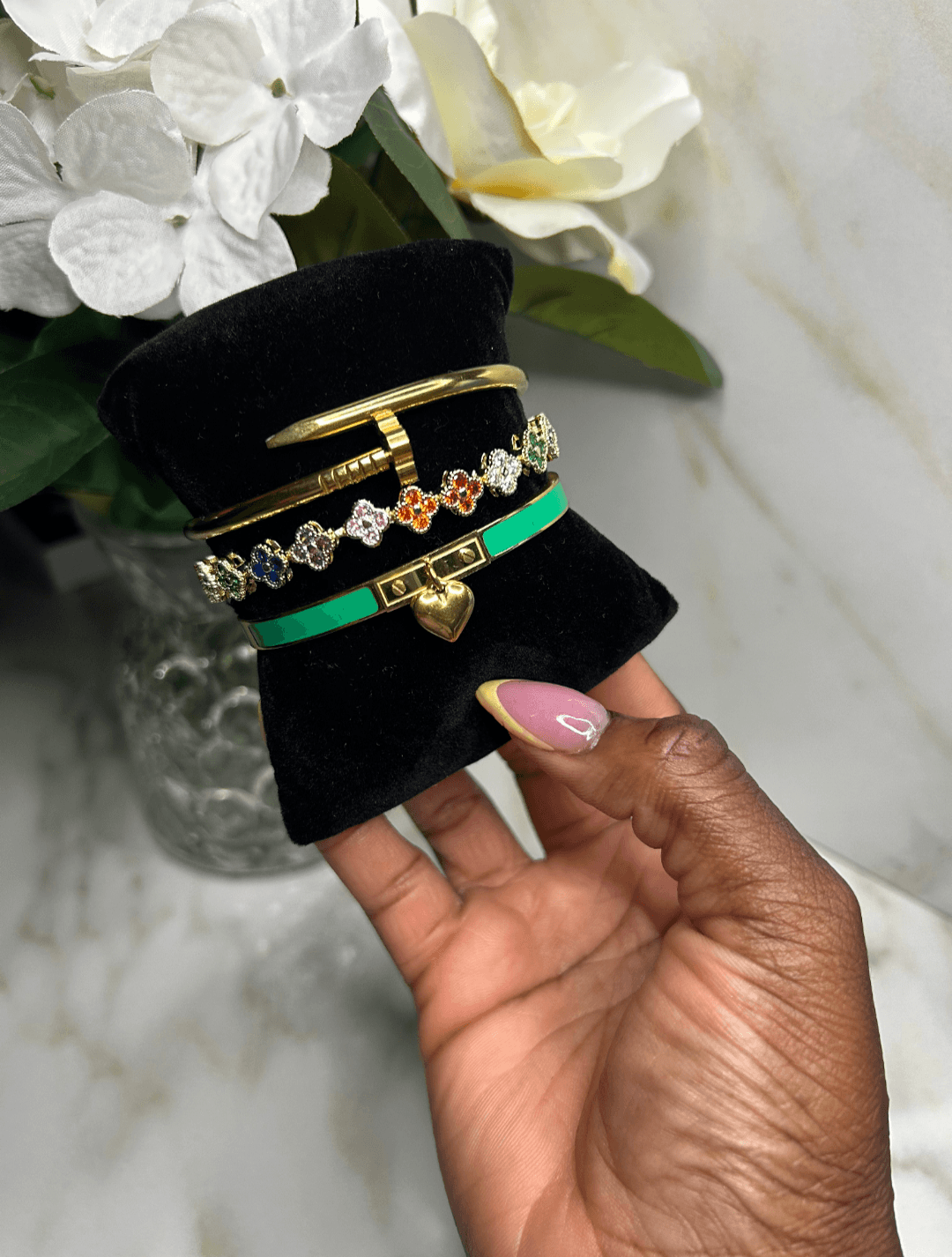The Royal Heart & Clover Stack showcasing three stylish bracelets in an elegant display.